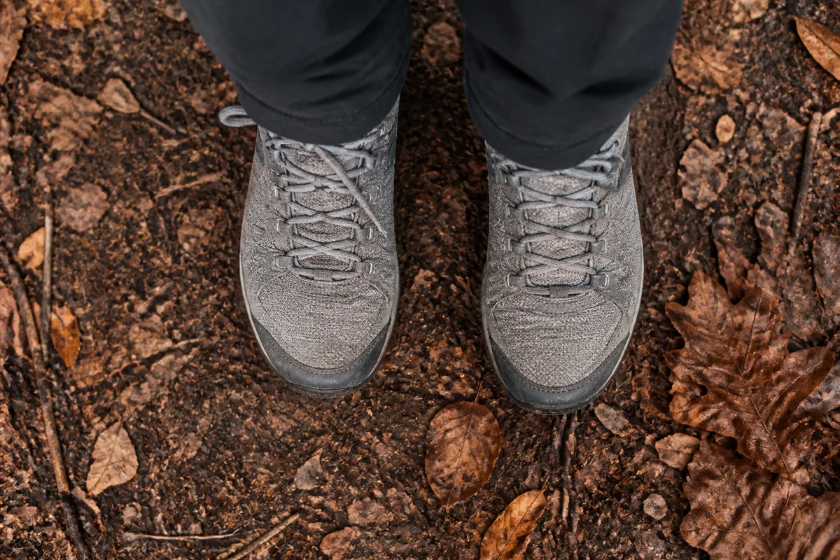 Chaussures de marche sur un chemin de terre couvert de feuilles rousses